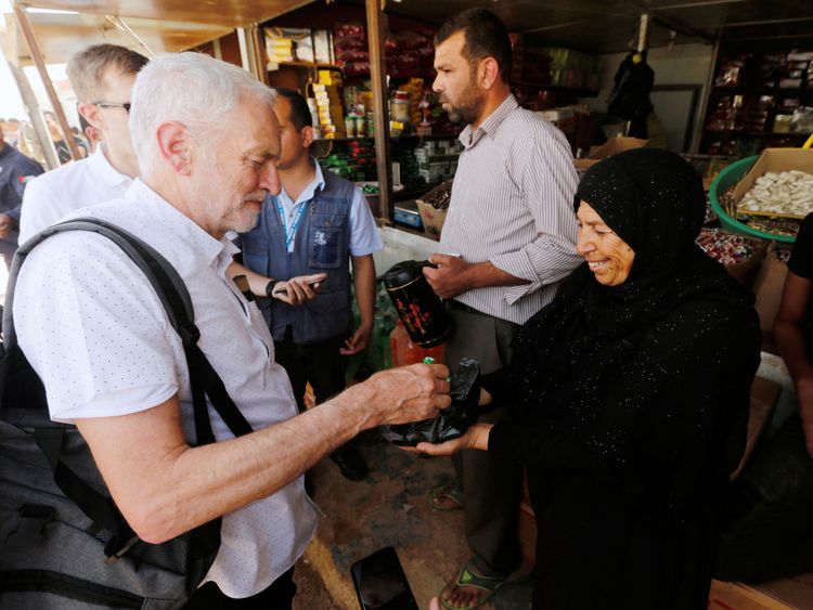 A Syrian refugee woman offers sweets to Britain&#39;s opposition leader Jeremy Corbyn during his visit to Al Zaatari refugee camp, in the Jordanian city of Mafraq, near the border with Syria, June 22, 2018. REUTERS/Muhammad Hamed