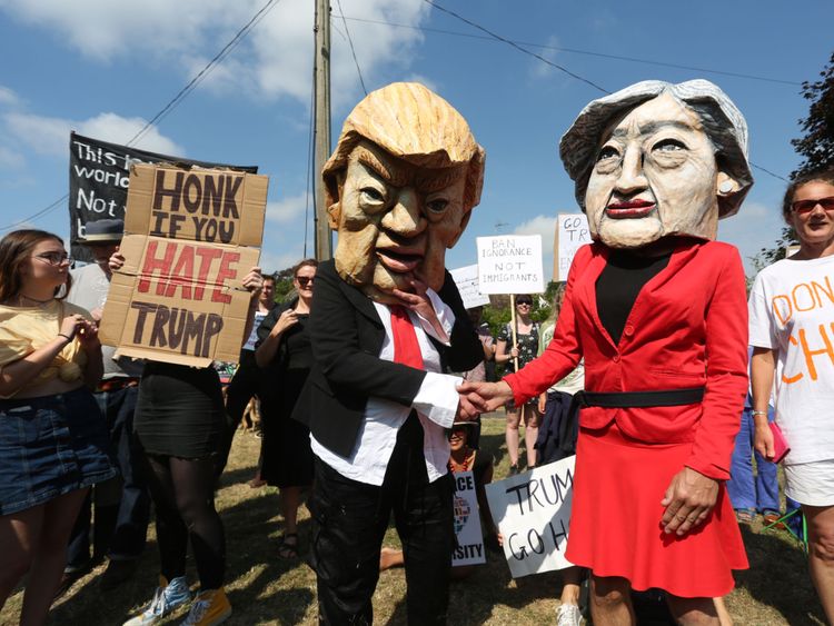 Protesters wearing masks depicting US President Donald Trump and Britain&#39;s Prime Minister Theresa May join other protesters against the UK visit of US President Donald Trump demonstrate outside Chequers