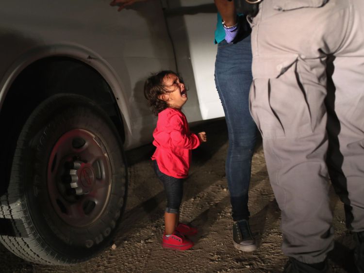 A two year old Honduran asylum seeker cries as her mother is searched and detained
