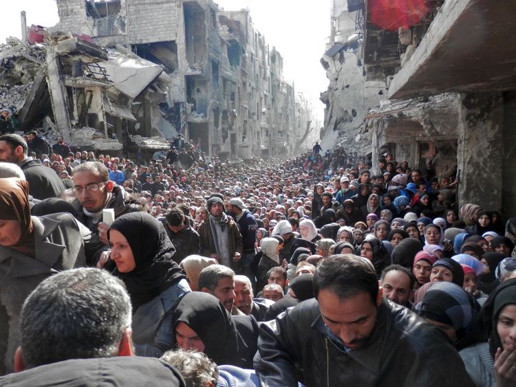 A now iconic image showed crowds of people queuing for food aid at Yamouk camp