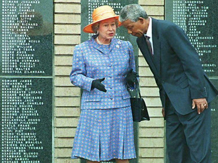 SOWETO, SOUTH AFRICA - MARCH 23: President Nelson Mandela leans forward as he speaks with Queen Elizabeth II at Avalon cemetery in Soweto, outside Johannesburg 23 March. The Queen unveiled a memorial to commemorate, 600 black soldiers who died when the SS-Mendi sank in the English Channel during World War I , in 1917. (COLOR KEY: Mandela wears dark blue suit). AFP PHOTO (Photo credit should read WALTER DHLADHLA/AFP/Getty Images)