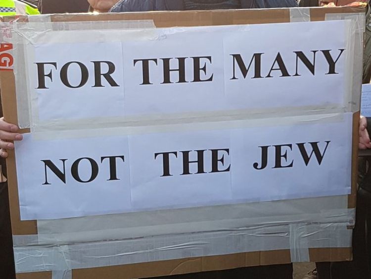 A campaigner holds a sign at an anti-Semitism protest outside Parliament