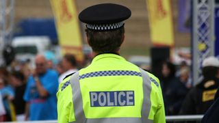 British police man backwards to the camera - Stock image