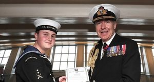 Sea cadet John Challenger being awarded a British Empire Medal (BEM) dressed in full service uniform.