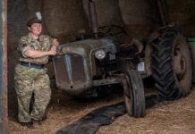 Reservist Tracy Llewellyn standing next to a tractor dressed in full service uniform.