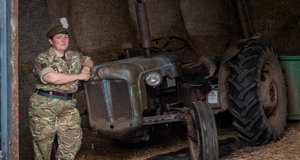 Reservist Tracy Llewellyn standing next to a tractor dressed in full service uniform.